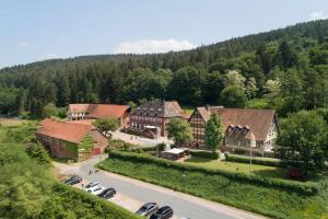 eine Luftansicht eines Hauses mit auf einem Parkplatz geparkt in der Unterkunft Landhotel der Schafhof Amorbach in Amorbach
