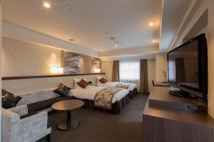 a hotel room with a bed and a flat screen tv at Matsue Excel Hotel Tokyu in Matsue