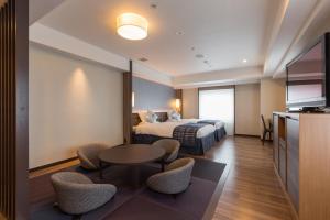 a hotel room with a bed and a table and chairs at Matsue Excel Hotel Tokyu in Matsue +49 photos
