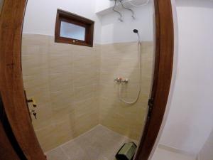 eine Dusche mit einer Glastür in einem Badezimmer in der Unterkunft Sama Sama Amed in Amed + 37 Fotos