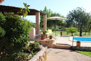 taras z parasolem i basenem w obiekcie Son Garbeta w Manacorze