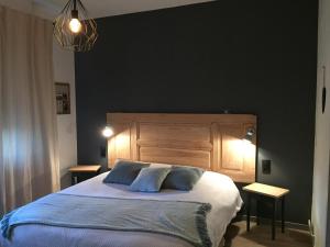 ein Schlafzimmer mit einem großen Bett mit blauen Kissen in der Unterkunft L'Ecrin des Saveurs in Schwenheim