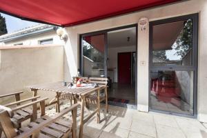 a patio with a table and chairs and a sliding glass door at VILLA DEL Ré 10 in La Flotte