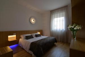 um quarto com uma cama e um vaso de flores em Hotel San Domenico Al Piano em Matera