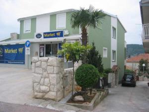 a building with a palm tree in front of it at Room-Delux- with a modern bathroom- - Primosten -Lokvice 6 in Primošten +18 photos