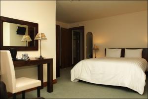 a bedroom with a bed and a desk and a chair at All the Twos Lodge in Clifden