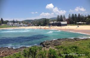 a beach with a bunch of people in the water at Kiama Executive in Kiama