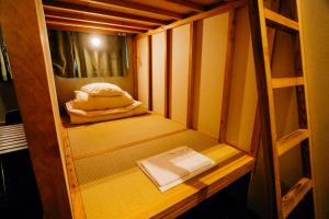 Habitación pequeña con litera y libro en AIEN Coffee & Hostel en Chatan