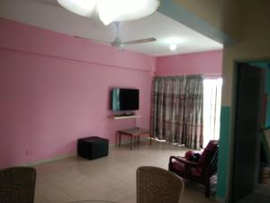 波德申阳光海湾度假酒店的客厅设有粉红色的墙壁和平面电视。