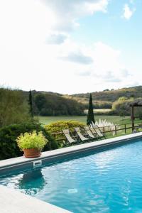 a swimming pool with chairs and a view of a field at Villa Le Caggia in Sovicille