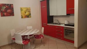 a kitchen with red cabinets and a table and chairs at CasArcieri mare in Barletta