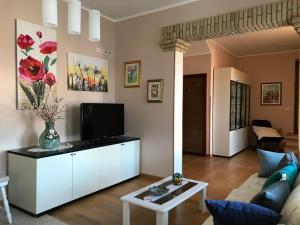 uma sala de estar com um sofá e uma televisão em Villa Dei Fiori - casa vacanza em Capoterra