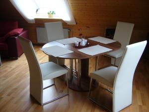 ein Esszimmer mit einem Tisch und weißen Stühlen in der Unterkunft Ferienwohnung Waldblick in Munster im Heidekreis
