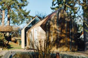 ein kleines Holzhaus mit dreieckigem Dach in der Unterkunft Haus am Schilf in Wieck