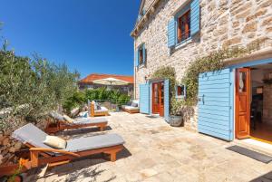 ミルナにあるVilla Vicina Heritage villa for 9,Milna - close to restaurants and shopsの建物の隣にパティオ(椅子、テーブル付)