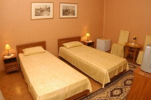 two beds in a room with two tables and two lamps at Peron in Debrecen