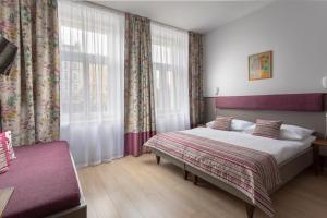 una camera con un grande letto e una finestra di Prague Centre Plaza a Praga