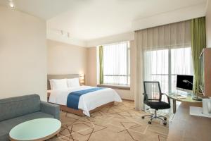 una camera d'albergo con letto e divano di Holiday Inn Express Chengdu West Gate, an IHG Hotel a Chengdu