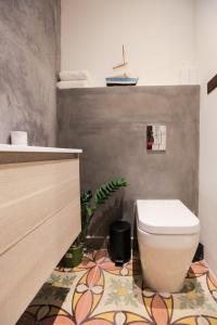 a bathroom with a toilet and a tile floor at Valletta - Hastings Studios in Valletta