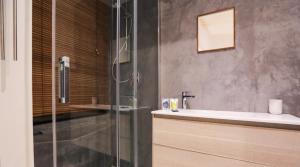 a bathroom with a glass shower and a sink at Valletta - Hastings Studios in Valletta