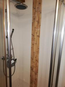 a shower with a wooden curtain in a bathroom at Casinha do Talasnal in Lousã