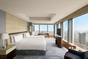 Jing An Shangri-La, Shanghai - sits centrally amid Puxi's iconic landmarks, uniquely positioned nearby Jing'an temple客房内的一张或多张床位
