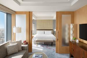 
a hotel room with a bed and a tv at Jing An Shangri-La, Shanghai in Shanghai

