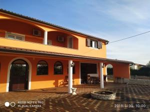 an orange house with a patio in front of it at Apartment Dorina in Buje