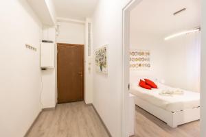 ein weißes Zimmer mit einem Bett und einer Tür in der Unterkunft YouHosty - Pantigliate 8 in Mailand