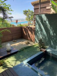 a backyard with a swimming pool and a wooden fence at Kaiza in Nanjo