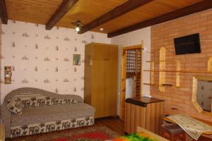 a room with a brick wall with a bed and a television at Agrousadba Nesvizhskaya in Nyasvizh
