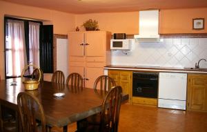 a kitchen with a wooden table and a table and chairs at Casa Blasco in Artieda