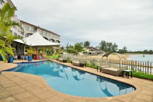 una gran piscina con sillas y un edificio en BON Hotel Waterfront Richards Bay, en Richards Bay