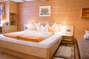 - une chambre avec un grand lit dans un mur en bois dans l'établissement Bauernhof Bethuber, à Matrei in Osttirol
