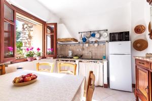 una cocina con una mesa con un bol de fruta. en Domu Ala - ByNos Homes en Baunei