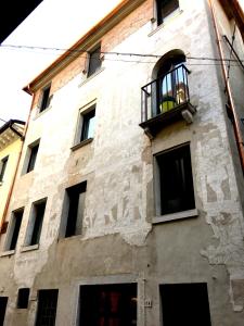 a white building with a balcony and a window at Palazzo Bianchetti in Treviso