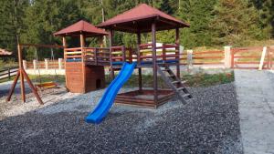 a playground with a slide and a swing set at Vila Balerina in Mitrovac