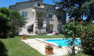 a house with a swimming pool in front of it at Domaine de Lazuel in Aubenas