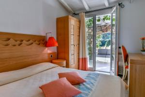 a bedroom with a bed and a sliding glass door at Hotel Garden Beach in Castiadas +182 photos