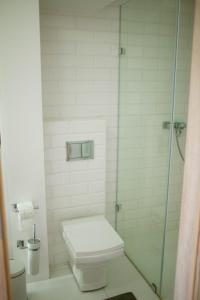 プウトゥスクにあるFlat White Apartament Pułtuskのバスルーム(トイレ、ガラス張りのシャワー付)