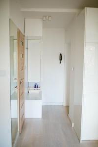 an empty room with white walls and wooden floors at Flat White Apartament Pułtusk in Pułtusk