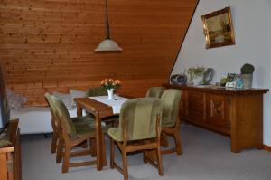 - une salle à manger avec une table, des chaises et un lit dans l'établissement Ferienwohnung Schultze, à Munster im Heidekreis