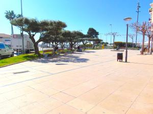 a sidewalk with trees and a street light at Apartaments Voramar in Cambrils