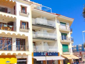 un edificio blanco alto con balcones en una calle en Apartaments Voramar, en Cambrils