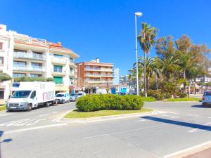 a street with cars and a truck driving down a street at Apartaments Voramar in Cambrils