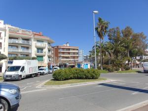 a street with cars and a truck driving down a street at Apartaments Voramar in Cambrils