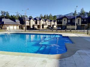 una gran piscina frente a algunas casas en Casa Robles Pucon, en Pucón