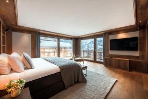 a bedroom with a bed and a balcony with a television at Haus Leytron in Zermatt
