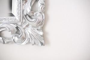 un espejo de plata colgado en una pared blanca en Country House Barone D'Asolo, en Asolo