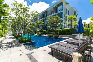 una piscina frente a un edificio en The Title Comfort Condotel, en Rawai Beach